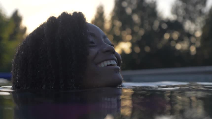 Woman in swimming pool smiles and laughs