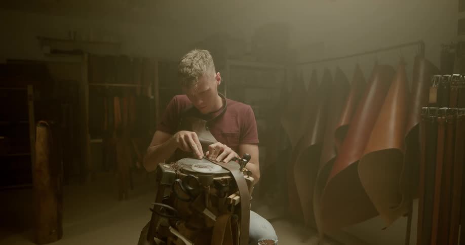 A man stretching leather over a log
