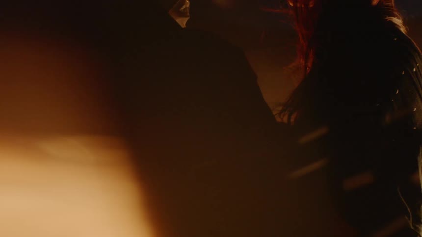 A man and woman hug by the campfire at night