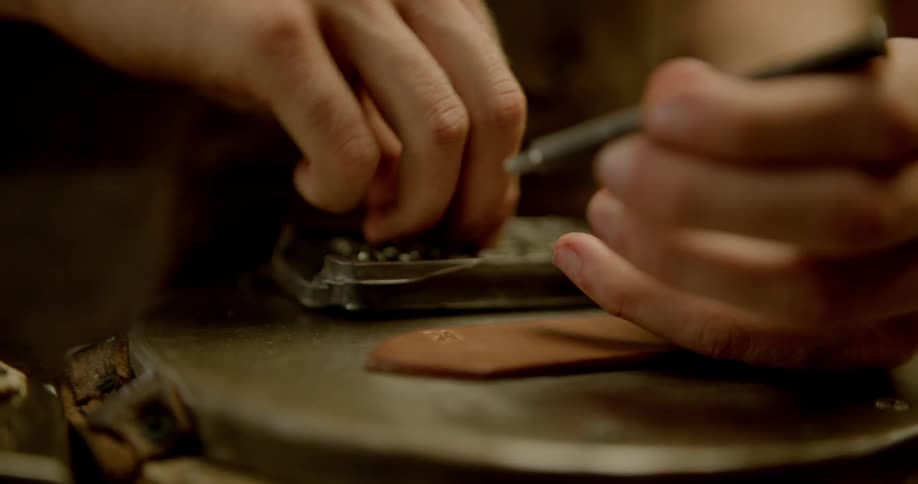 A tool is used to punch holes in leather strips