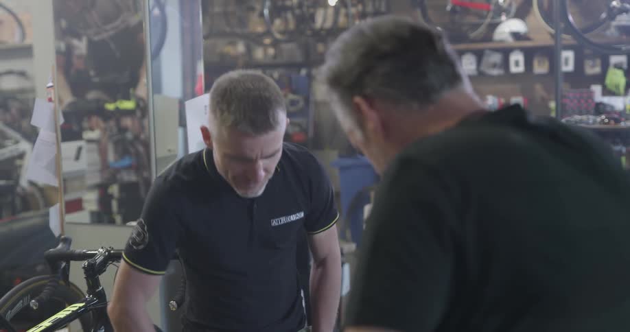Two men speak to each other about a bicycle