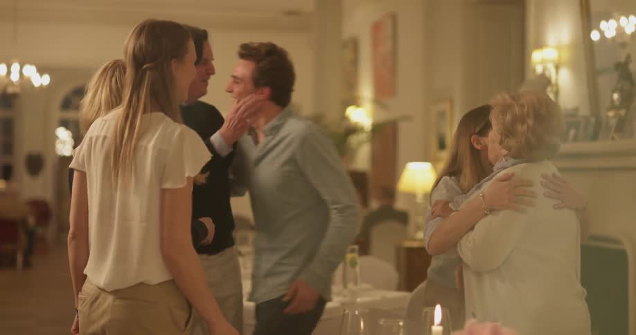 A group of people are greeting each other at a restaurant