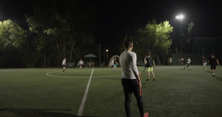 A group of people are playing soccer at night