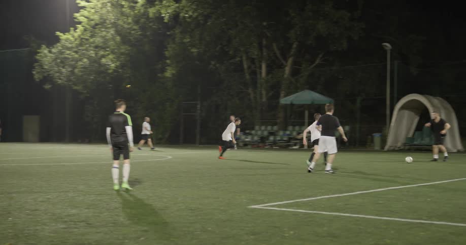 Two teams of boys play soccer on a field