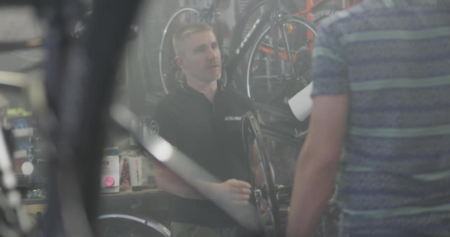 A bicycle shop employee helps a customer