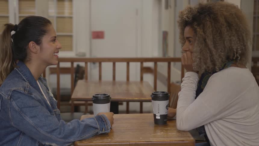 Two woman at a table with coffee cups