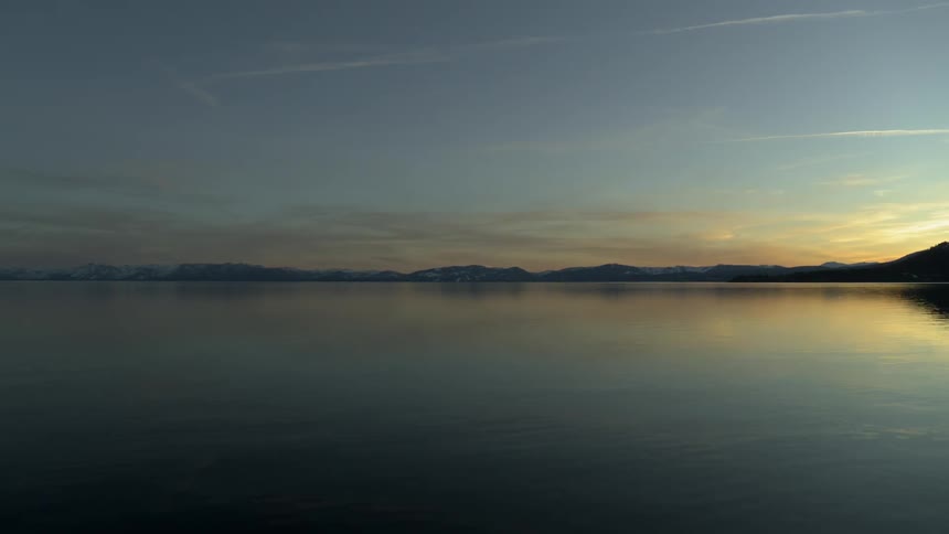 A large body of water with hills and mountains in the distance