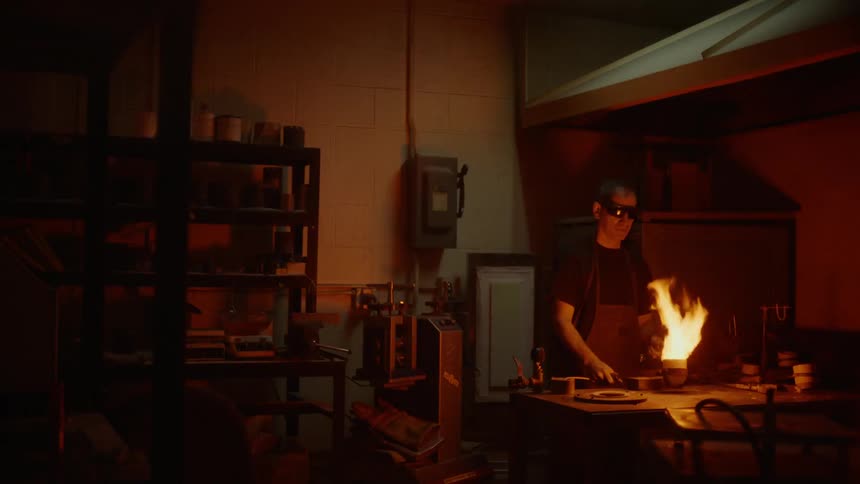 A man is using fire indoors