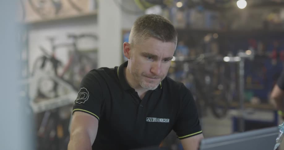 Man looks at computer screen in bike shop