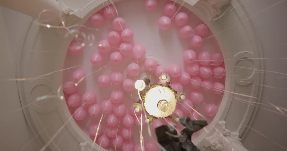 Pink balloons floating on the ceiling inside building
