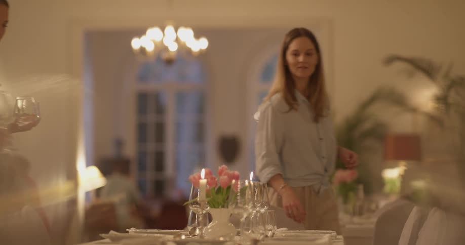 Two women place glasses on a table