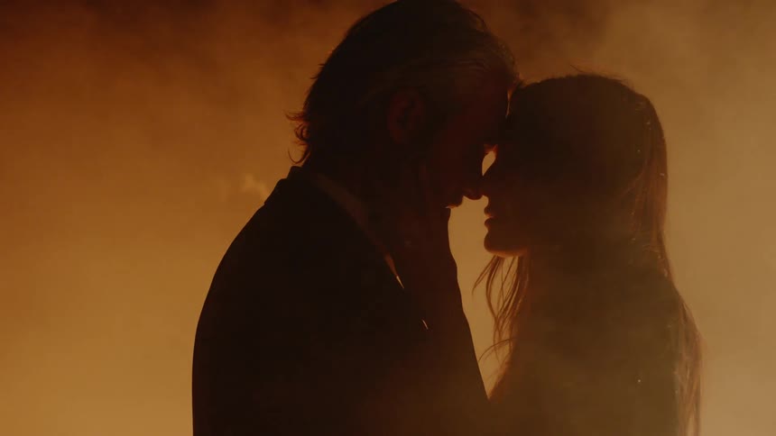 Man and woman dancing surrounded by fire and ash