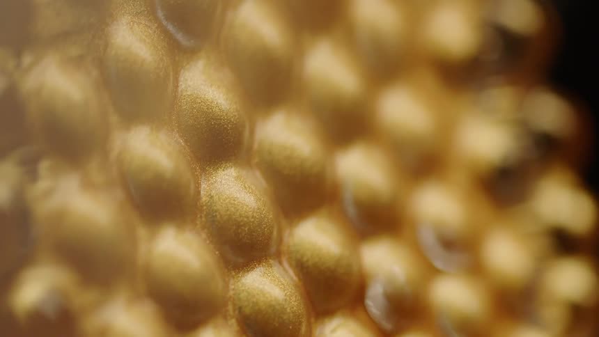 Close up of a gold dimpled surface
