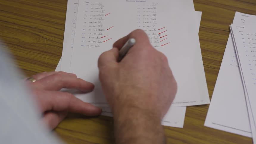 Man grades a failing test with a red pen
