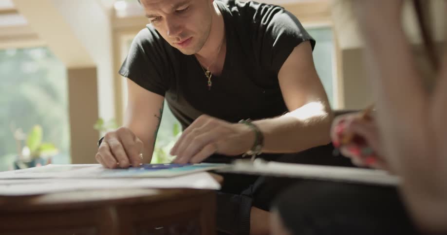 Man and woman work on different tasks at coffee table