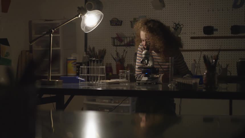 A woman working at a desk with a bright lamp