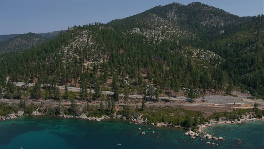 Cars driving along the edge of a lake