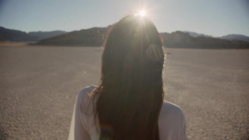 A woman is standing outside at day time