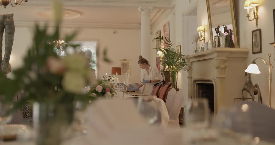 Woman places silverware down at a formal dining table