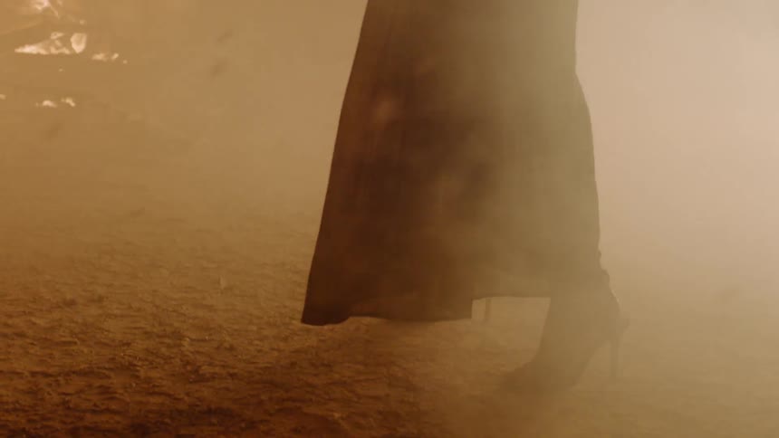 A woman stands in front of a fire