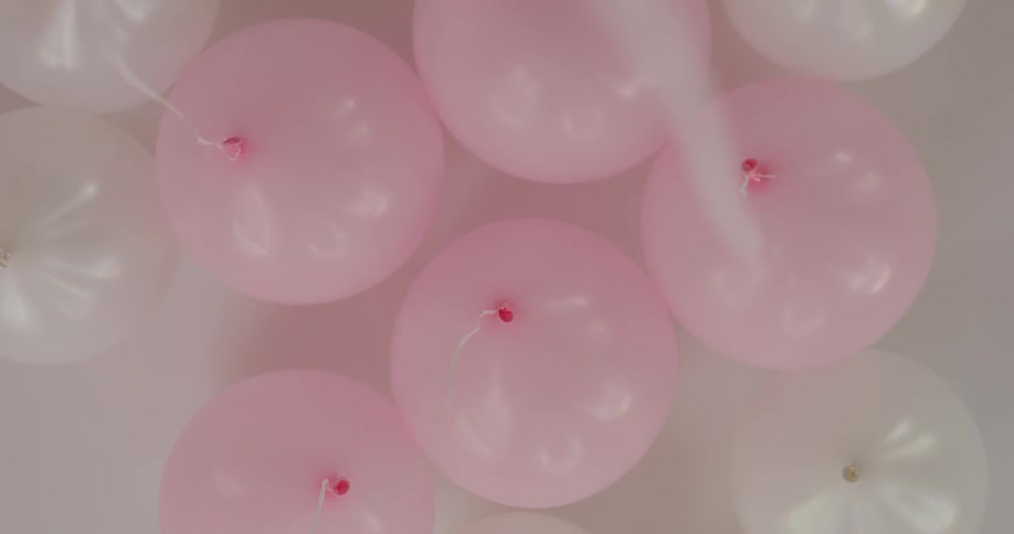 A lot of pink balloons on the ceiling