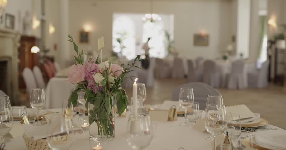 Candle burns on a set table in a banquet hall