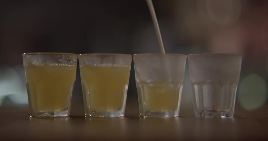 Liquid is being poured into four glasses