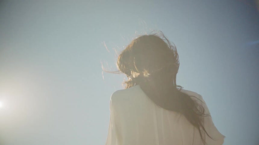 A woman stares out while turning slightly