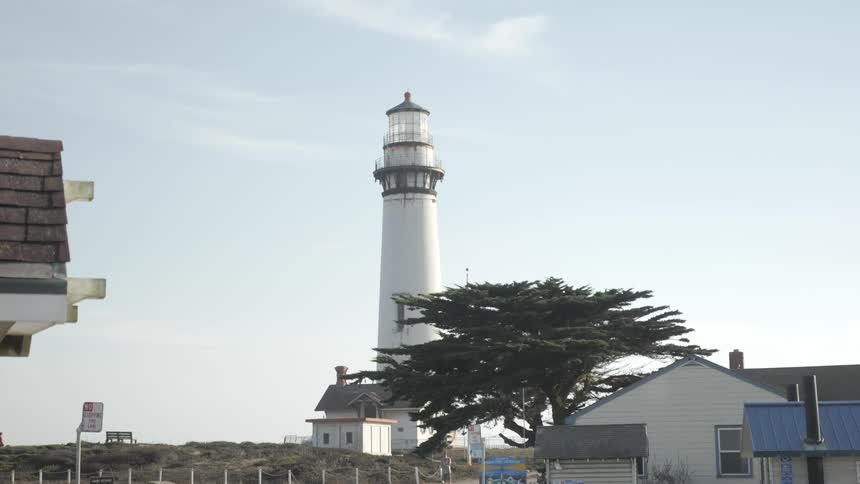 Lighthouse near buildings on a clear day