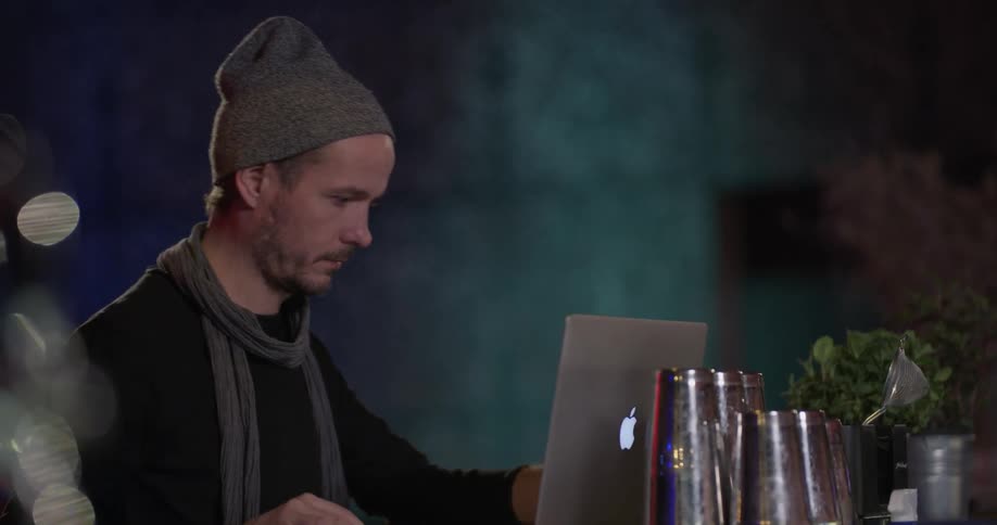 Man walks up to bar sets down laptop and opens it