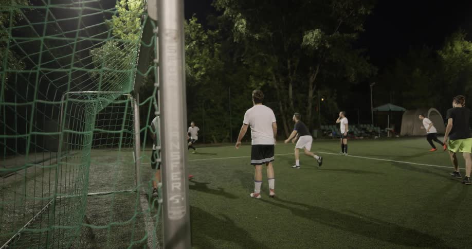 A group of people are playing soccer at night