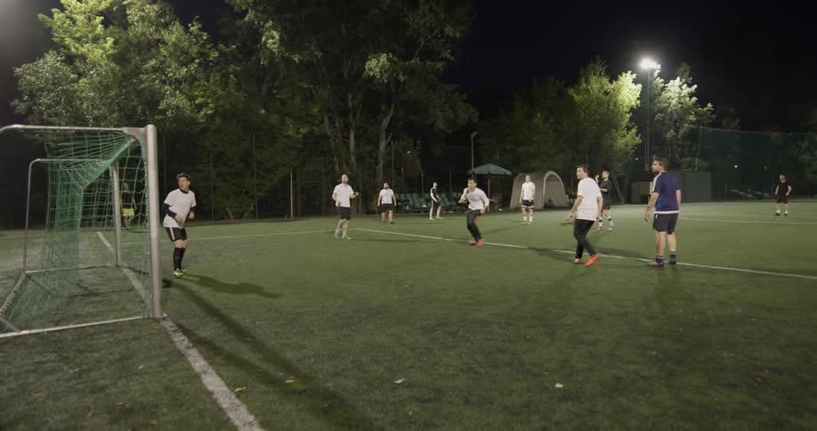 A group of people are playing soccer at night