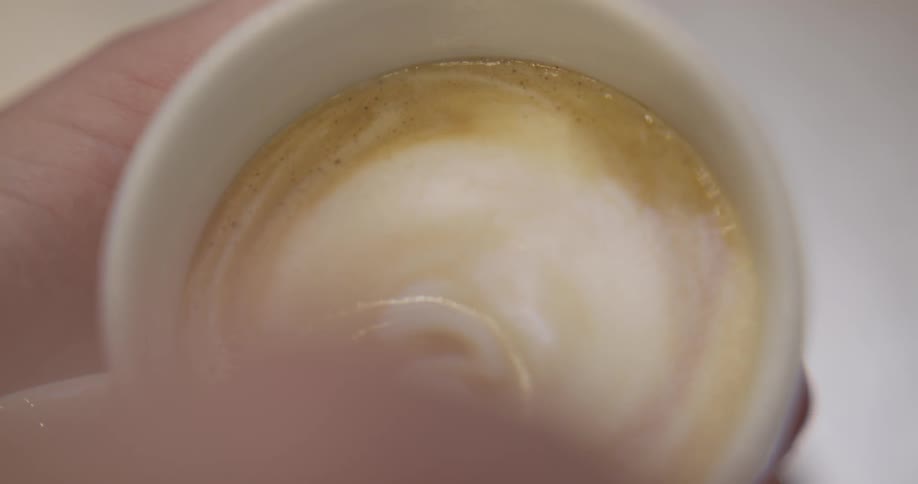 Person pours cream in a cup of tea