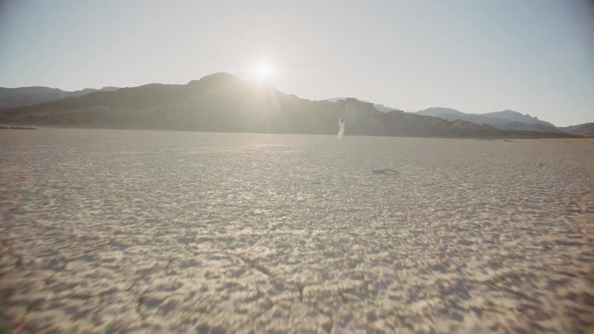 A dry lake bed with a car in it