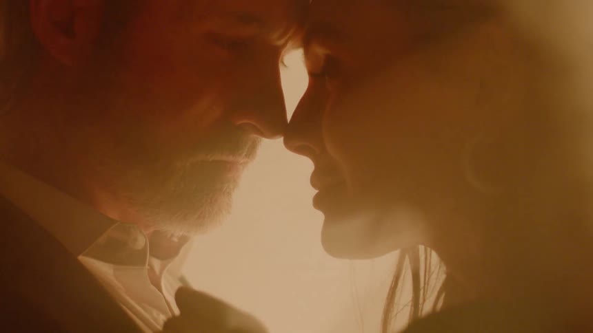 A man and woman lean foreheads together