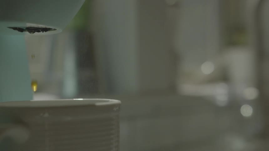A bit of coffee dripping into a cup