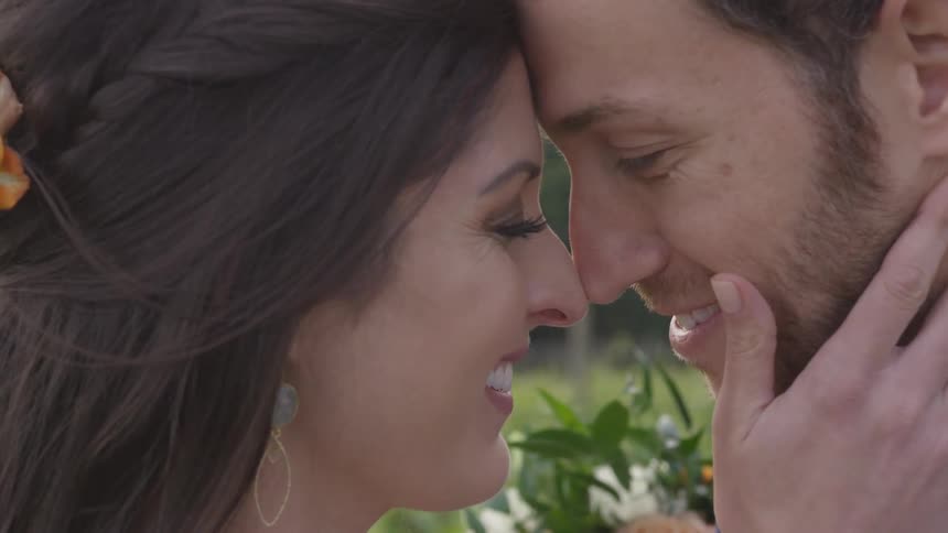 A man and woman kissing in front of flowers