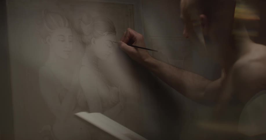 Male artist painting fine details onto a large piece of art