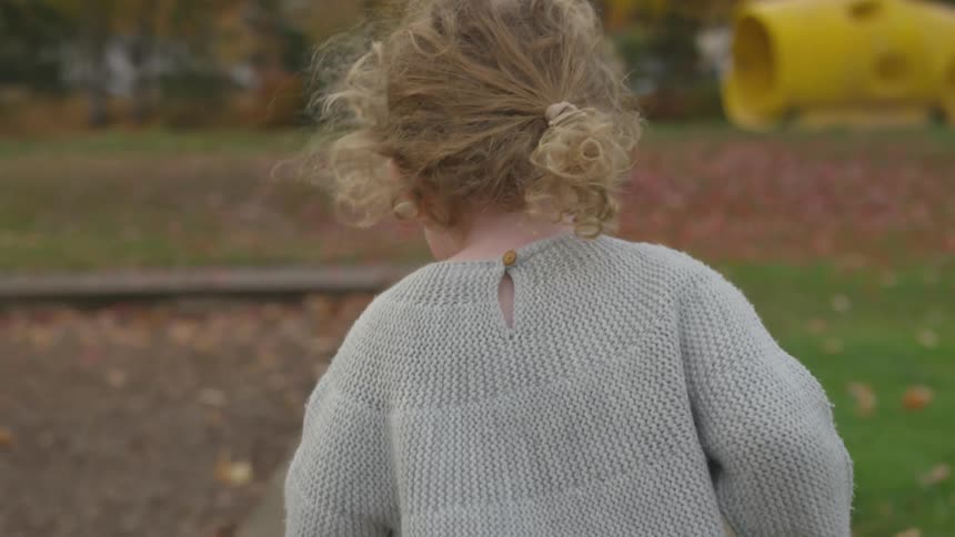 A girl runs through a playground