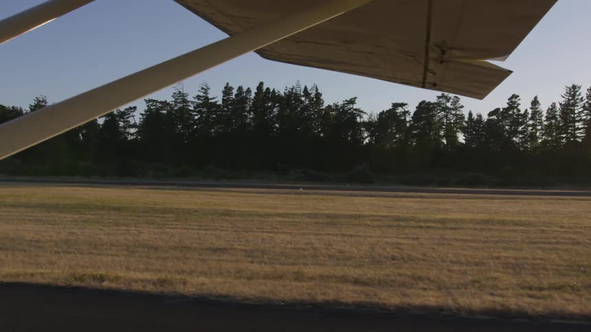 A plane taking off next to a grassy field