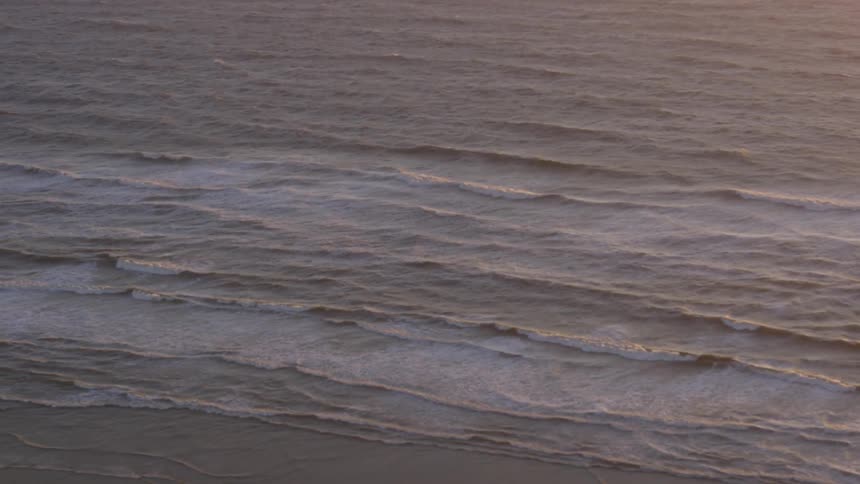 Small waves crashing onto the sand