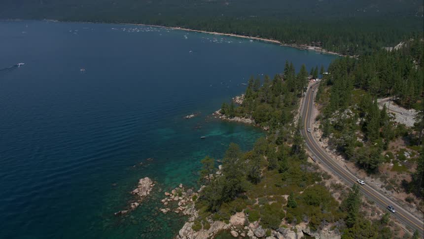 Cars driving on a road next to a lake