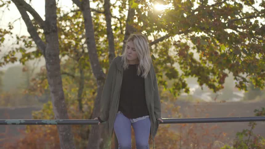 A woman is outside by a tree