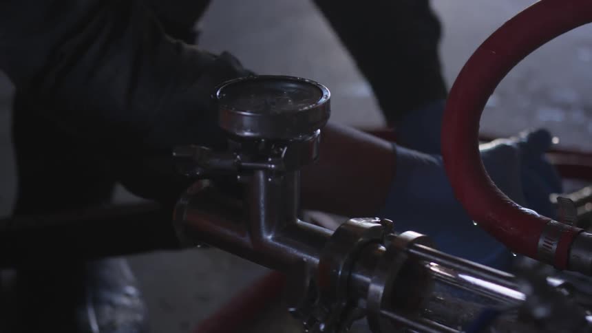Person adjusts hose in factory