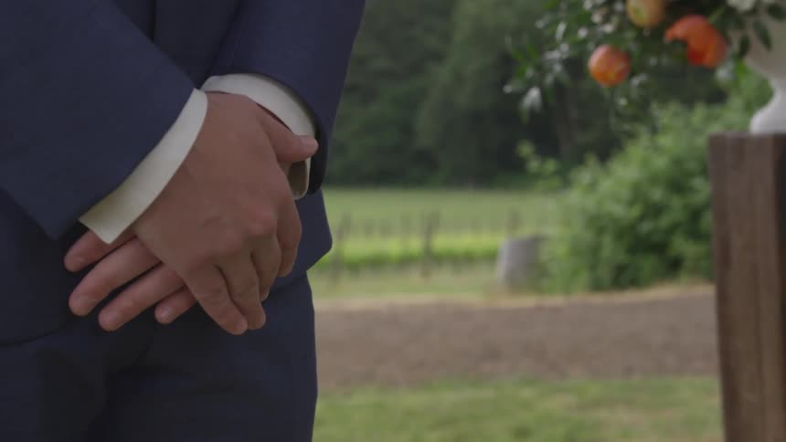 A man's hands are crossed in front of him