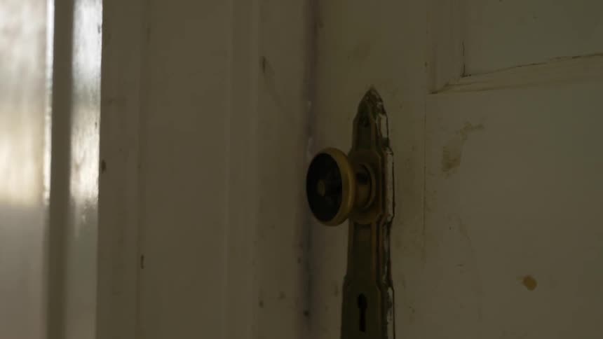 A door handle that is turning while a door is shaking in a house