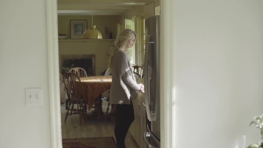 Woman looking out a window in a kitchen