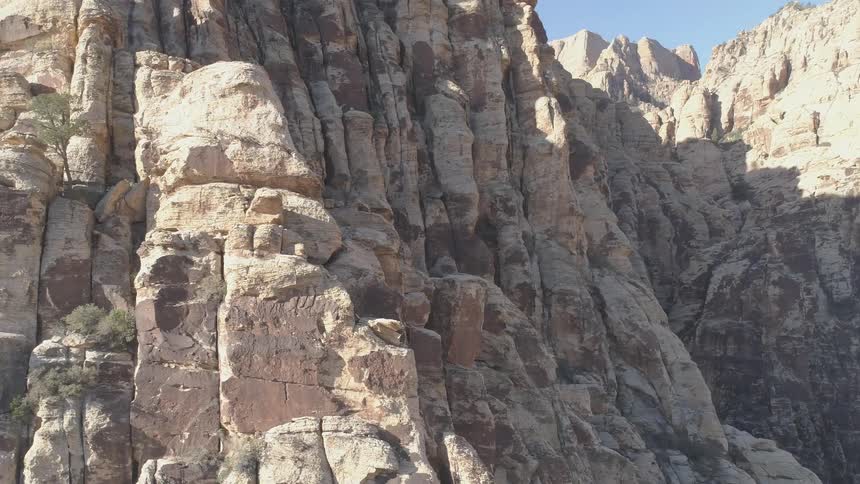 The camera pans out and circles the side of a mountain a bit on a bright sunny day