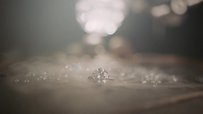 Smoke blows over a pile of jewels and a ring