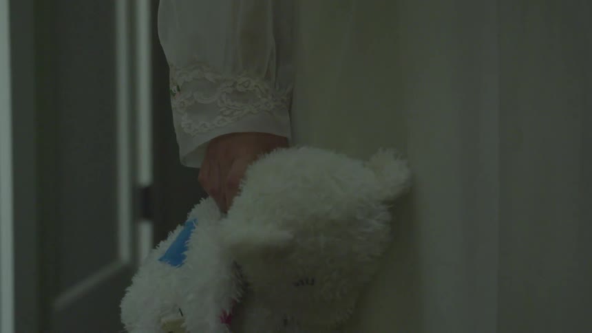 A person is holding a bear indoors
